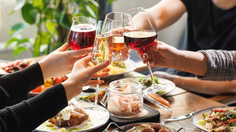 Diners clinking glasses of wine in a restaurant.