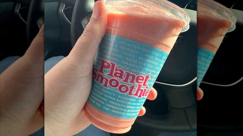 Hand holding Captain Kid smoothie from Planet Smoothie