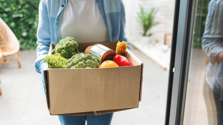person holding a box of groceries