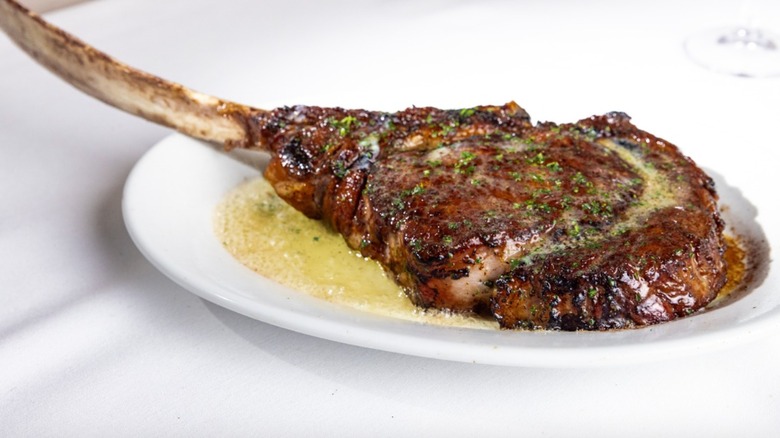 Tomahawk steak on white plate