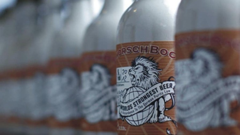 One schorschbock beer in focus in row of beer bottles with lions roaring on labels