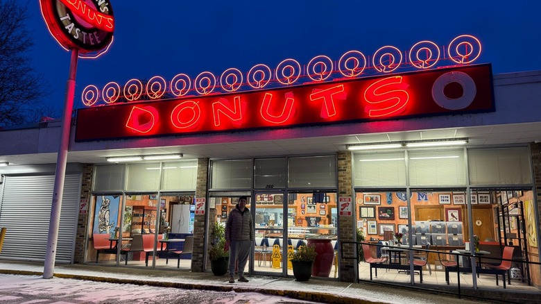 A man standing outsight of Gibson's Donuts, a donut shop located in Memphis