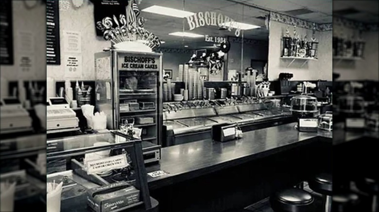 Black-and-white photo of Bischoff's Ice Cream counter in front of large mirror with white lettering.