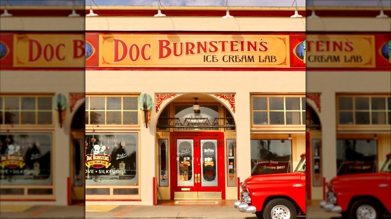 Exterior shot of Doc Burnstein's Ice Cream Lab with red trim on the building and a classic red pickup out front.