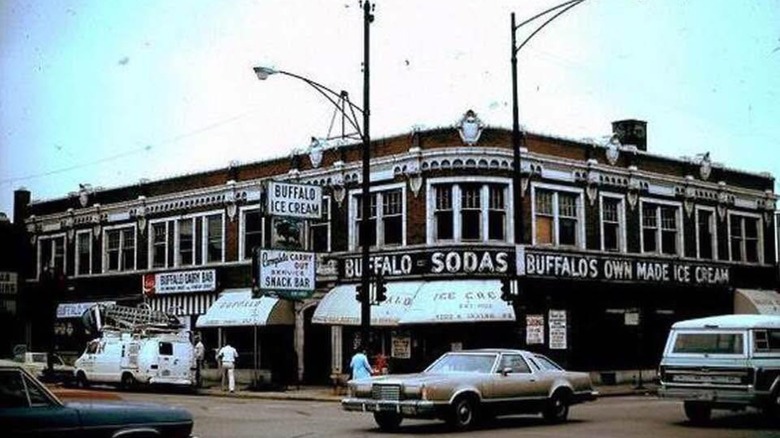 A 1978 exterior shot of The Buffalo Ice Cream Parlor from the opposite street corner. The signage wrapping around the building says "Buffalo Sodas, Buffalo's Own Made Ice Cream."