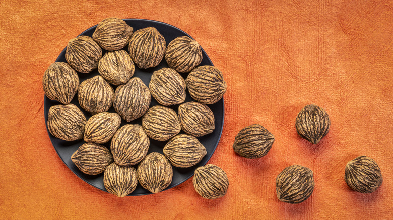 black walnuts in shells on a plate and off