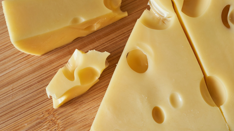 blocks of swiss cheese on wooden board