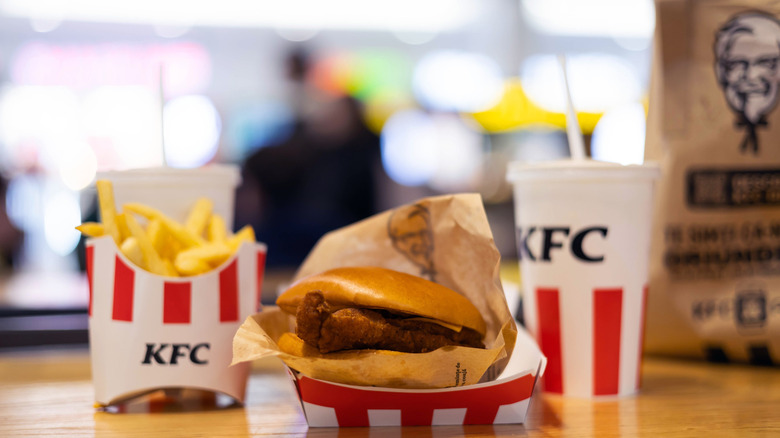 KFC chicken sandwich, fries and a beverage on a wooden table