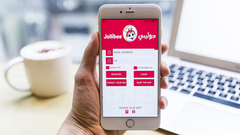 Hand holding a phone with the Jollibee app open