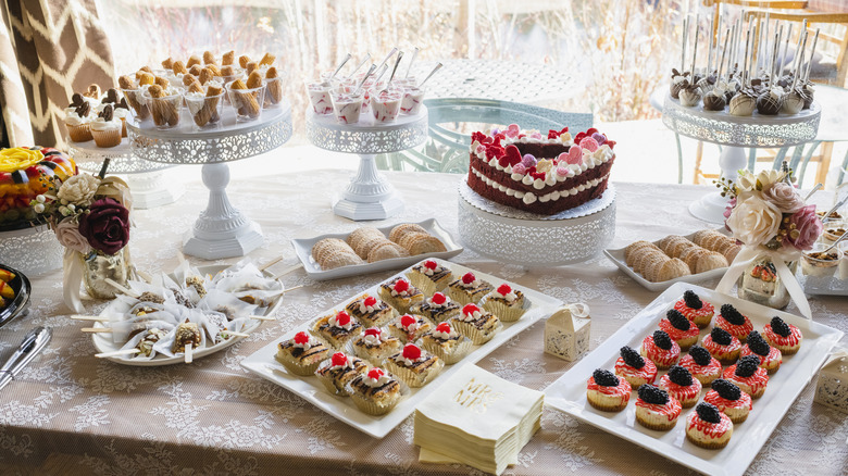 Assorted desserts displayed on a table in front of a window