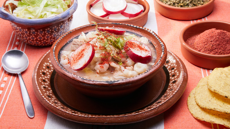 Mexican pozole surrounded by ingredients