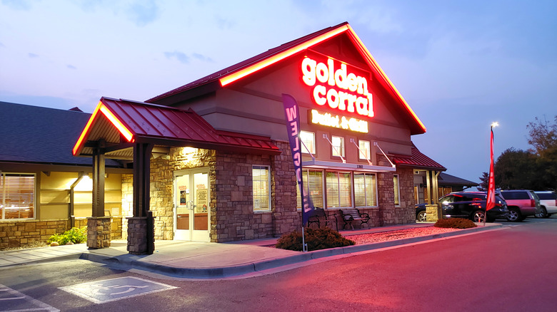 The exterior of a Golden Corral buffet and grill at night lit up in neon