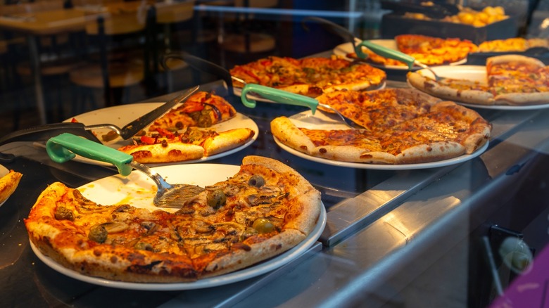 Various types of pizza on a buffet line