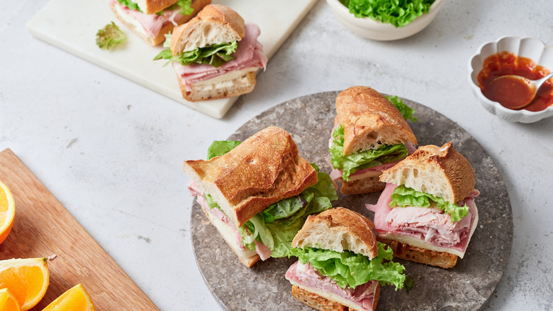 small baguette sandwiches on a gray plate and white board