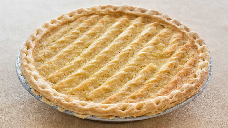 A pineapple pie in a metal tin on a table