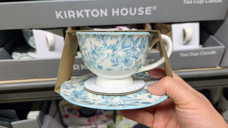 hand holding tea cup candle