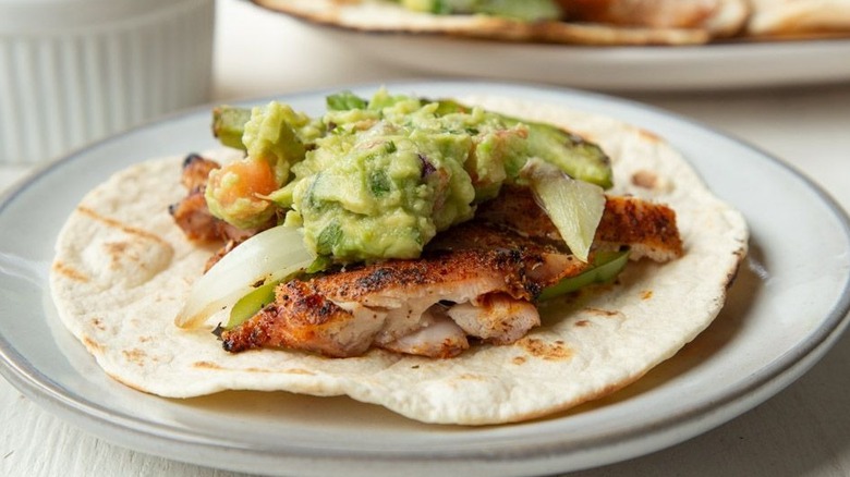 chicken, vegetables, and guacamole on a flour tortilla