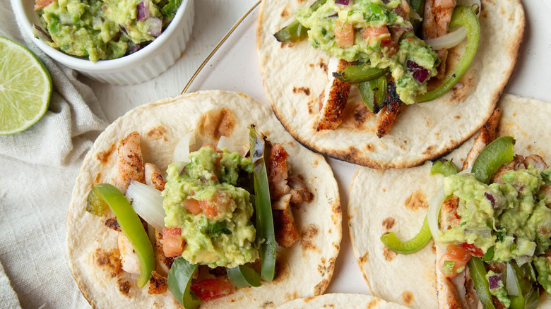 chicken, vegetables, and guacamole on a flour tortilla