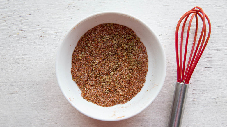 seasoning mix in white bowl next to red whisk