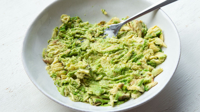 mashed avocado in a white bowl