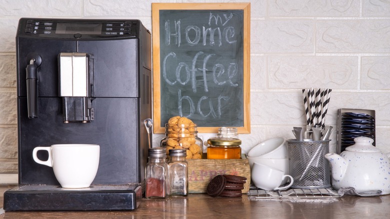 Coffee nook with coffee machine, cups, snacks, and a sign reading "My Home Coffee Bar"
