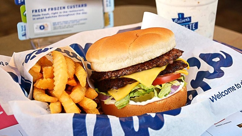 Culver's burger and fries in paper-lined container with a Concrete Mixer in the background.