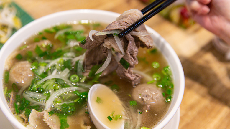 Closeup of bowl of pho with chopsticks