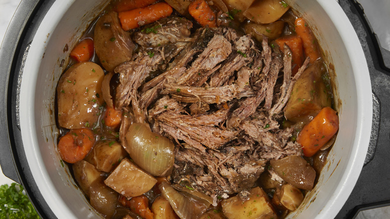 Slow cooker pot roast with potatoes, carrots, celery, onions and garlic.