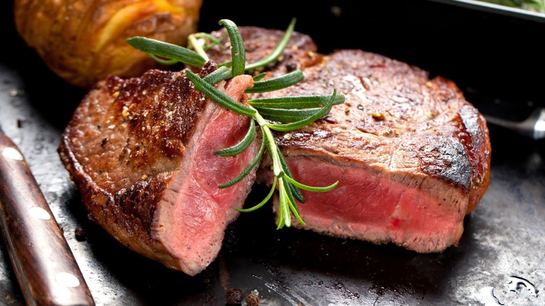 Cooked steak with a fresh rosemary sprig