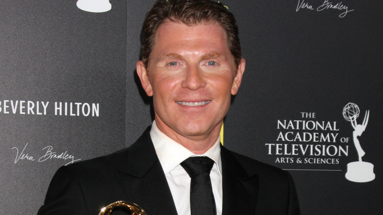 Bobby Flay smiles in a black tux on the Emmys red carpet