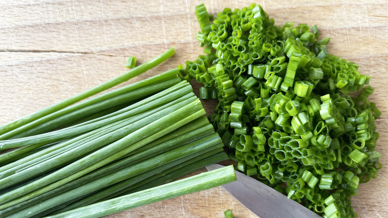 chopped chives on a wooden board