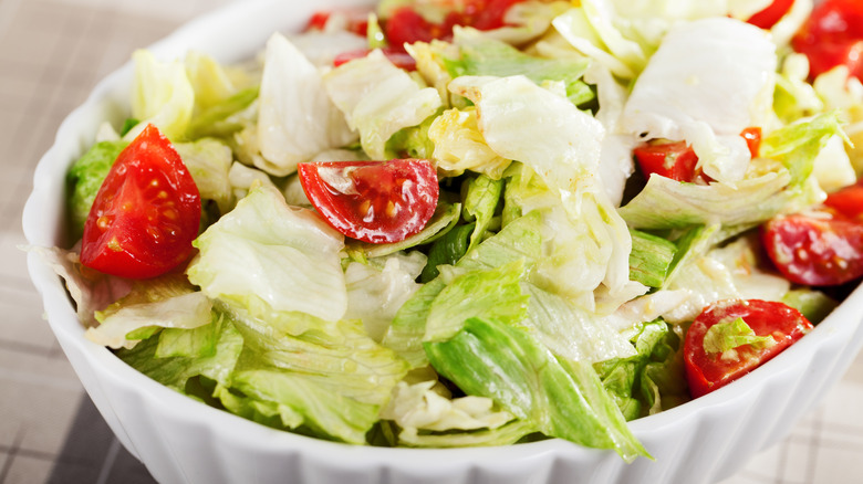 close up of simple salad with iceberg lettuce and quartered cherry tomatoes