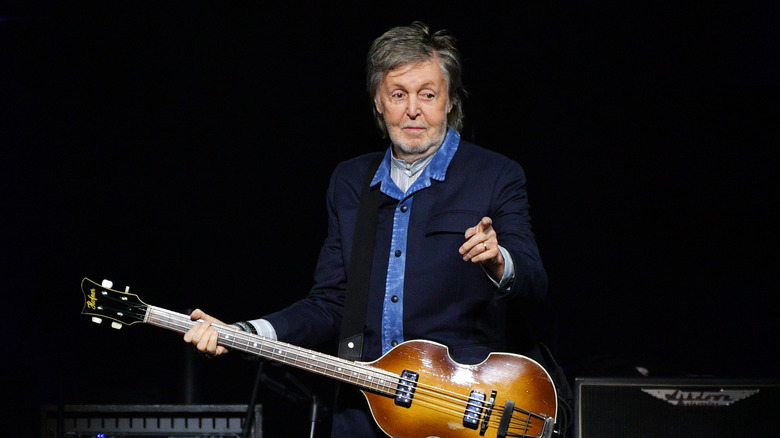 paul mccartney holding guitar at performance