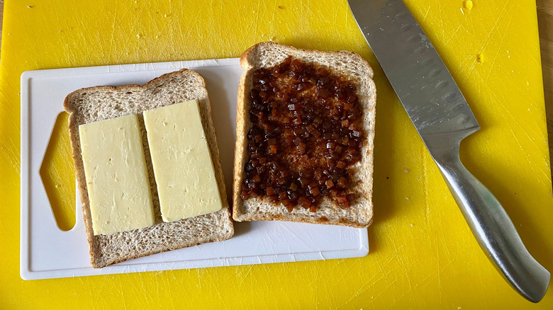 branston pickle and cheddar sandwich being prepared on cutting board
