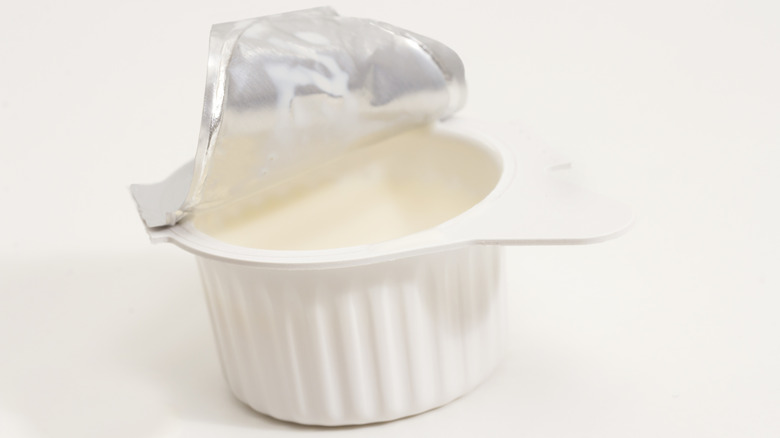 Open white plastic container of liquid coffee creamer