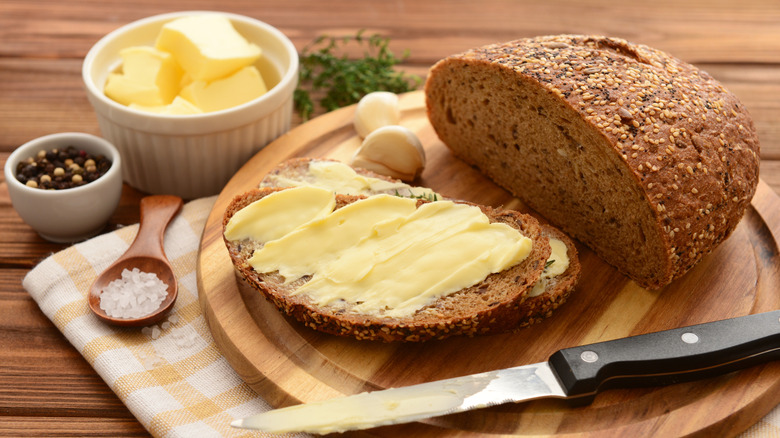 Sliced bread with butter and a knife