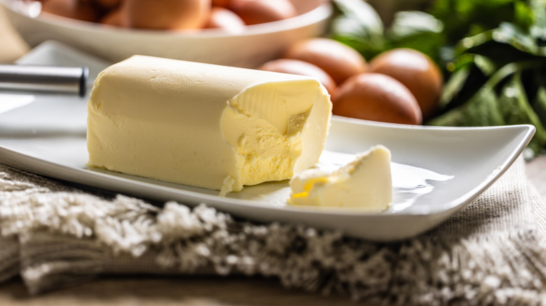 A stick of butter on a white dish