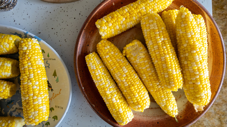 Cooked corn on serving platters.