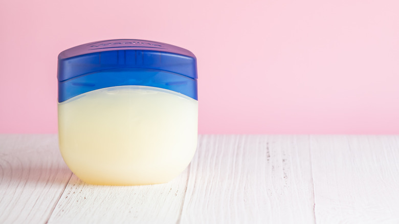 Tub of vaseline against a pink backdrop