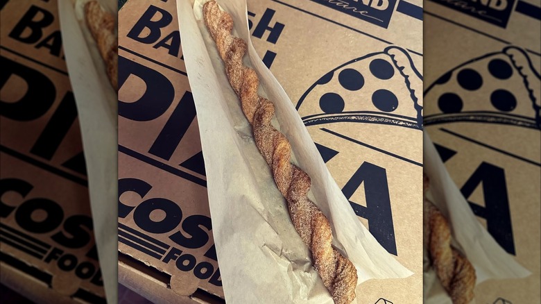 One twisted churro from Costco on top of a Costco pizza box