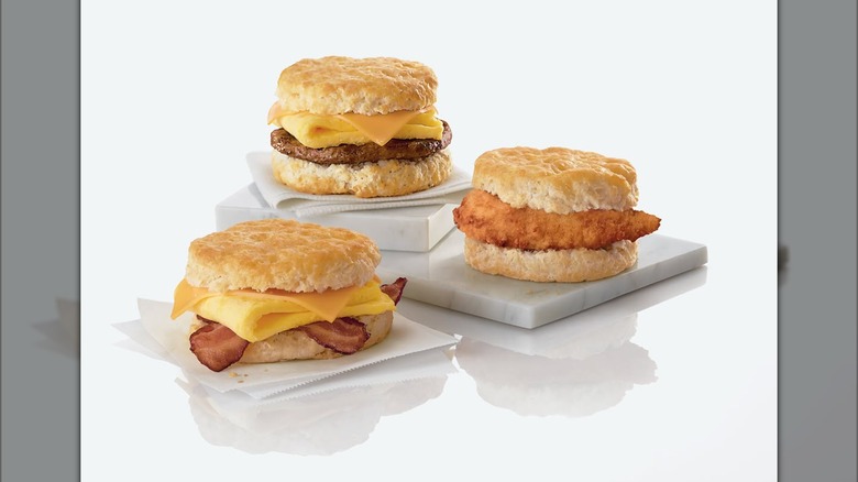 Three biscuit breakfast sandwiches from Chick-fil-A on display in a white void