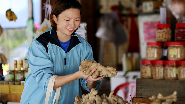A young woman shopping for fresh ginger