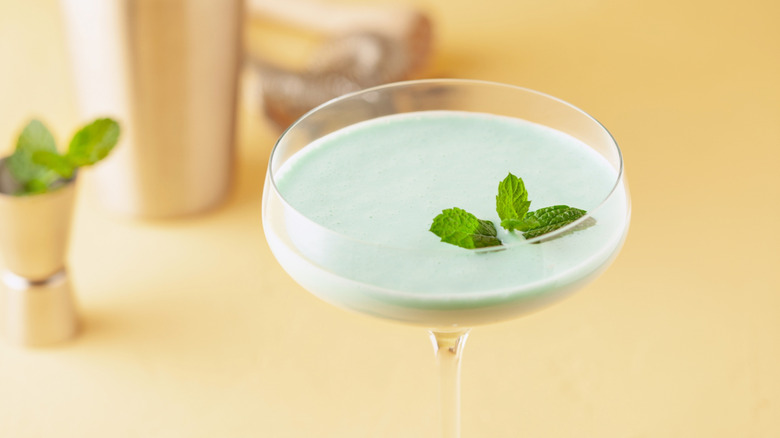 A grasshopper cocktail garnished with fresh mint leaves