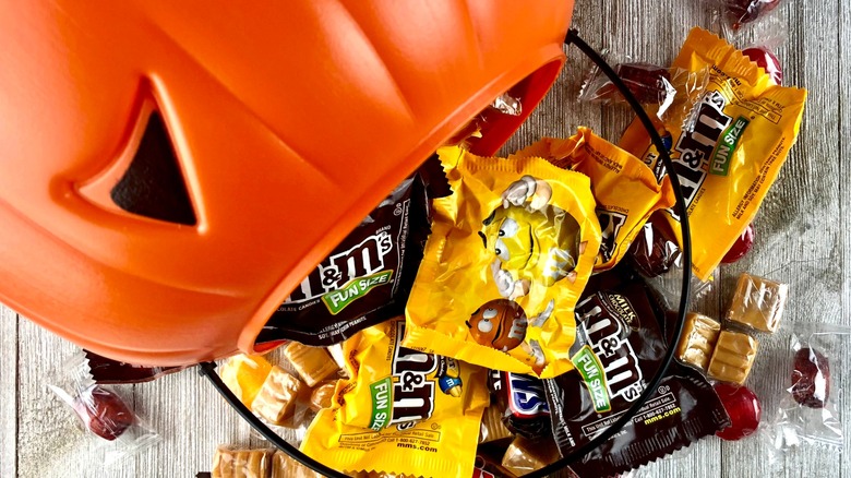 Halloween candy bucket spilling out packages of candy