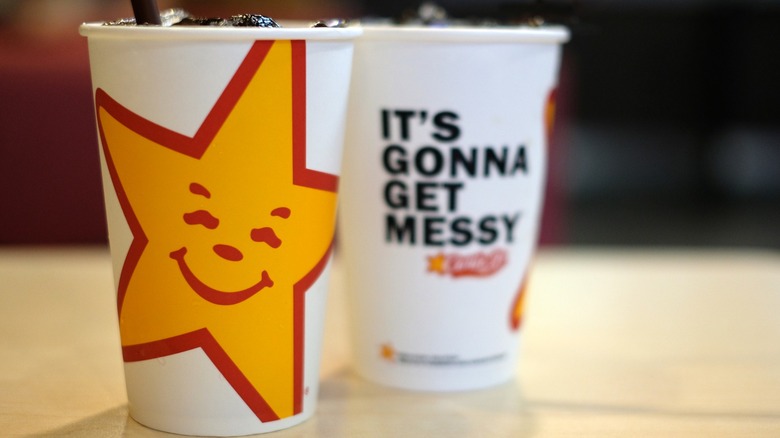 Carl's Jr. cups of soda on table