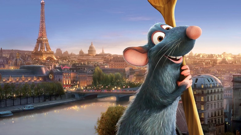 Remy from the Disney film Ratatouille smiling while holding a wooden spoon with the Eiffel tower in the background.