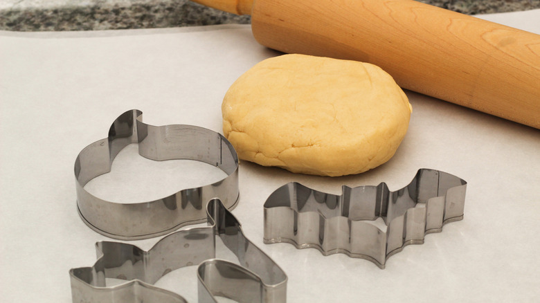 Metal Halloween cookie cutters with dough and rolling pin