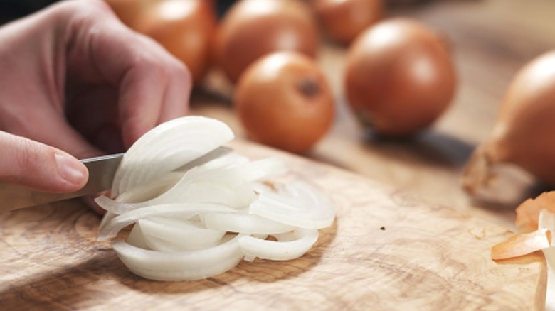 Person slicing onion up close