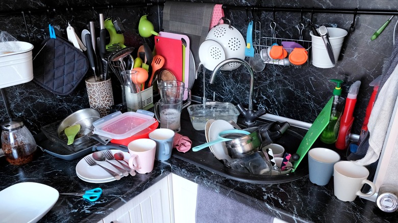 Disorganized kitchen cluttered with dishes and utensils