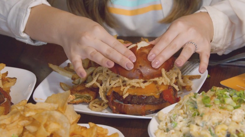 A person picking up a burger from Kuma's Corner.